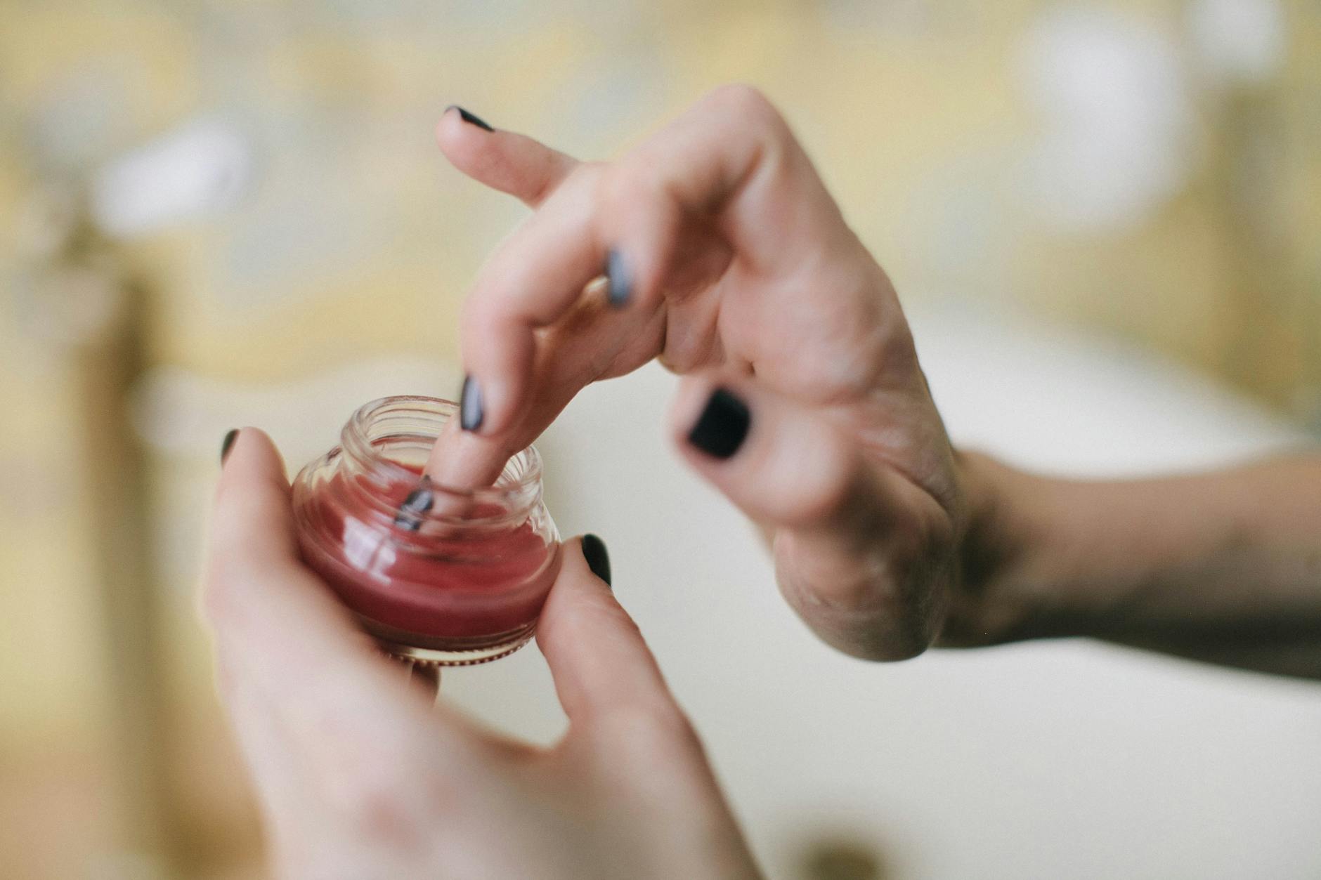 Kobieta zbliżeniowo nakłada odżywczy balsam na skórę dłoni