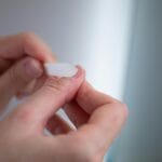 Dłonie pielęgnujące zniszczone paznokcie pilnikiem po manicure żelowym