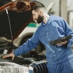 Mechanik w warsztacie sprawdza silnik auta przed długą trasą