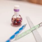 Olej do skórek i narzędzia do manicure ułożone na białym tle