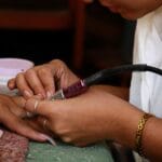 Zbliżenie na dokładne opracowanie paznokci podczas profesjonalnego manicure