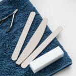 Narzędzia do skórek: cążki, kopytka, frezy – jak kupić zestaw, który nie zrobi krzywdy Zestaw narzędzi do skórek na niebieskim ręczniku w salonie manicure